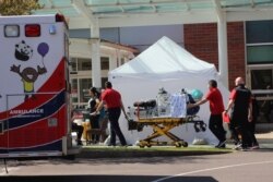 FILE - Health care workers wheel a gurney into Salem Hospital's emergency room in Salem, Oregon, April 9, 2020.