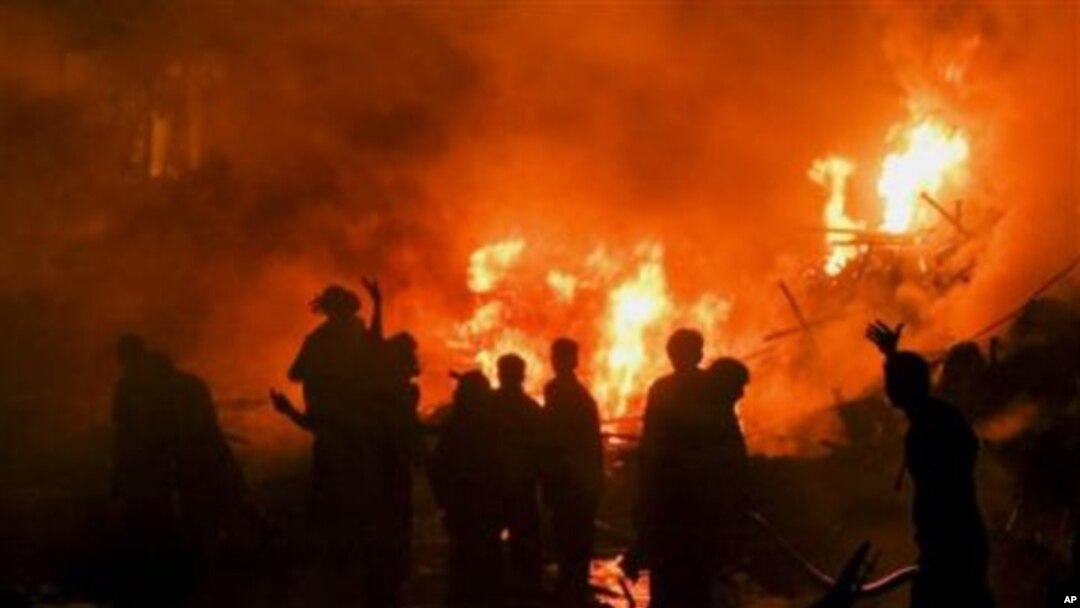 Pakistani firefighters struggle to extinguish fire at the site of a plane crash in Karachi, Pakistan, 28 Nov 2010