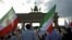 FILE - Activists hold flags during a demonstration against executions in Iran in Berlin, Germany, Sept. 3, 2016.