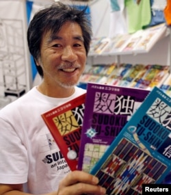 FILE - 'Father of Sudoku' Maki Kaji holds copies of the latest sudoku puzzles at the Book Expo, in New York, June 3, 2007.