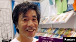 FILE - 'Father of Sudoku' Maki Kaji holds copies of the latest sudoku puzzles at the Book Expo, in New York, June 3, 2007. 