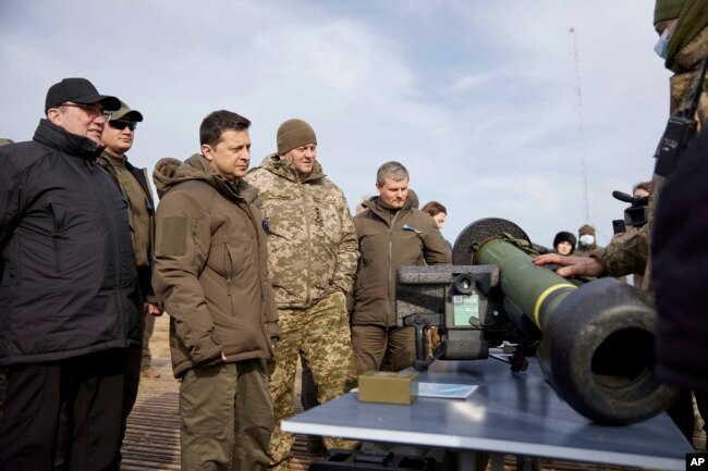 Presiden Ukraina Volodymyr Zelenskyy, kiri tengah, ditunjukkan senjata anti-tank NLAW selama latihan militer di luar kota Rivne, Ukraina utara, Rabu, 16 Februari 2022. (Kantor Pers Kepresidenan Ukraina via AP)