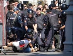FILE - Police officers detain protesters during an unsanctioned rally in the center of Moscow, Russia, July 27, 2019.
