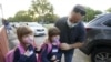 Anthony Sacco deja a sus hijas Angelina, de 7 años, (izquierda), y Victoria, de 5, para su primer día de clases en la primaria Fox Trail, el viernes 9 de octubre de 2020, en Davie, Florida.