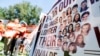 Manifestantes muestran las fotos de las víctimas de la matanza de Uvalde, en Texas, en una marcha contra las armas asalto en Washington DC, el 13 de julio de 2022. 