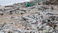 Seorang pria mengumpulkan plastik dan sampah-sampah lainnya yang berserakan di sepanjang pantai Kedonganan, Kabupaten Badung, Bali. (AFP)&nbsp;