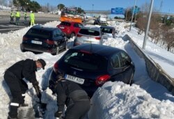 Miembros del ejército depejan la nieve acumulada entre los vehículos en la autopista M-40 de Madrid el 11 de enero de 2021.