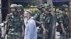 FILE - Armed police officers stand guard in Urumqi, Xinjiang Uighur Autonomous Region, June 29, 2013. 