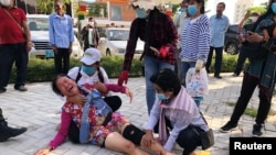A woman lies on the floor after security guards broke up a small protest near the Chinese embassy opposing alleged plans to boost Beijing's military presence in the country, in Phnom Penh, Cambodia October 23, 2020. (REUTERS/Heng Mengheang) 