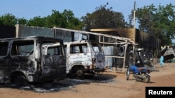 FILE - Burnt vehicles and houses are pictured on a street, after Boko Haram militants raided the town of Benisheik, west of Borno State capital Maiduguri.