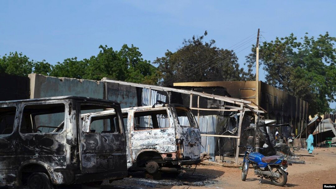 FILE - Burnt vehicles and houses are pictured on a street, after Boko Haram militants raided the town of Benisheik, west of Borno State capital Maiduguri.