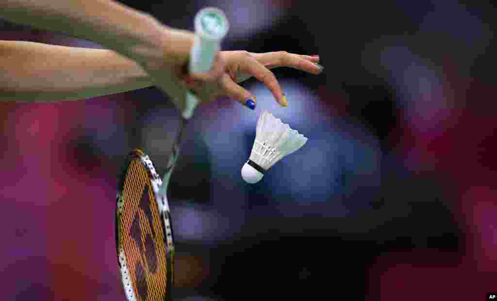 Reiko Shiota, de Jap&oacute;n, sirve durante un partido de dobles de badminton.