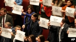 Opposition members of the Italian parliament display placards in Italian reading "Meloni where are you?" during a debate in Rome, Feb. 5, 2025, over the controversial repatriation of Libyan warlord Ossama Anjiem, also known as Ossama al-Masri.