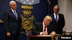 President Donald Trump signs an executive order he said would impose tighter vetting to prevent foreign terrorists from entering the United States at the Pentagon in Washington, Jan. 27, 2017. 