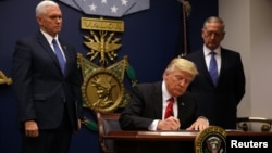 President Donald Trump signs an executive order he said would impose tighter vetting to prevent foreign terrorists from entering the United States at the Pentagon in Washington, Jan. 27, 2017. 