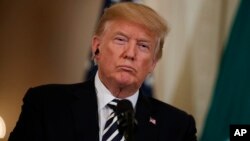 President Donald Trump listens to Italian Prime Minister Giuseppe Conte during a news conference in the East Room of the White House, in Washington, July 30, 2018.