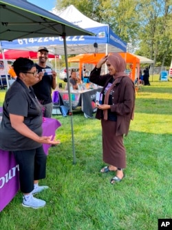 In this undated photo provided by Munira Abdullahi, right, the Democratic candidate chats with potential voters in her home city of Columbus, Ohio.