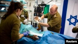 Petugas medis militer Israel merawat seorang pria Suriah yang terluka di sebuah rumah sakit di dataran tinggi Golan, wilayah Suriah yang diduduki Israel (foto: dok).