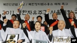 Participants holding pictures of a Northern prison camp and N. Korean children in hunger shout slogans after they got their heads shaved during an anti-North Korea rally demanding a legislation of N. Korean human rights laws at a plaza in front of the Seo