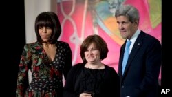In this March 8, 2013 file photo, Russian human rights activist, journalist Elena Milashina, is honored at the State Department in Washington by then First lady Michelle Obama and Secretary of State John Kerry.