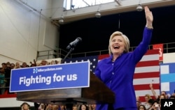 Democratic presidential candidate Hillary Clinton, left, reacts as she takes the stage at a rally, Monday, June 6, 2016, in Long Beach, CA, eight years after saying she was unable to "shatter that highest, hardest glass ceiling."