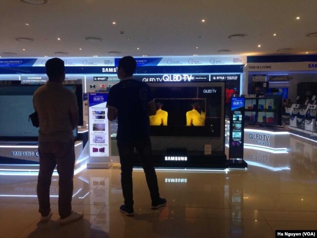 FILE - Shoppers check out smart TVs in Hanoi. Analysts recommend Vietnam retrain workers for the technology sector to meet the demand for new skills.