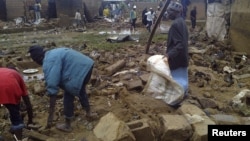 Residents sort through the ruins of a building after a flood devastates Nigeria's central city of Jos, July 24, 2012.