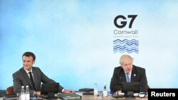 El primer ministro británico, Boris Johnson (Der), y el presidente francés, Emmanuel Macron, se sientan alrededor de la mesa directiva de la reunión del G-7 en Carbis Bay, Cornwall, Reino Unido, el 11 de junio de 2021.