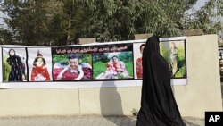 A woman looks at pictures of people killed by shelling by Turkish warplanes in the northern town of Rania in Sulaimaniya province, 260 km (161miles) northeast of Baghdad, August 23, 2011