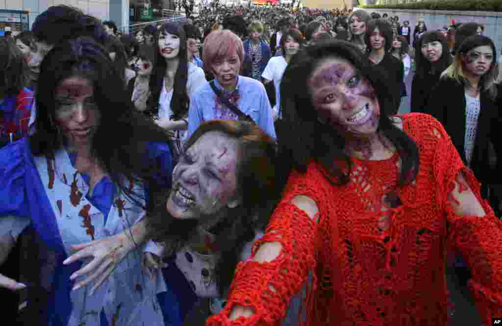 Orang-orang memakai rias wajah zombie dalam sebuah acara Halloween di Tokyo Tower, Tokyo. (AP/Shizuo Kambayashi)