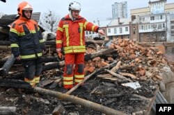 Ukrainian rescuers access at the debris for clearing at a residential building, partially destroyed after a missile strike on Kharkiv on Jan. 30, 2023.