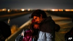 FILE - Cuban migrant Mario Perez holds his wife as they wait to be processed to seek asylum after crossing the border into the United States on Jan. 6, 2023, near Yuma, Ariz. 