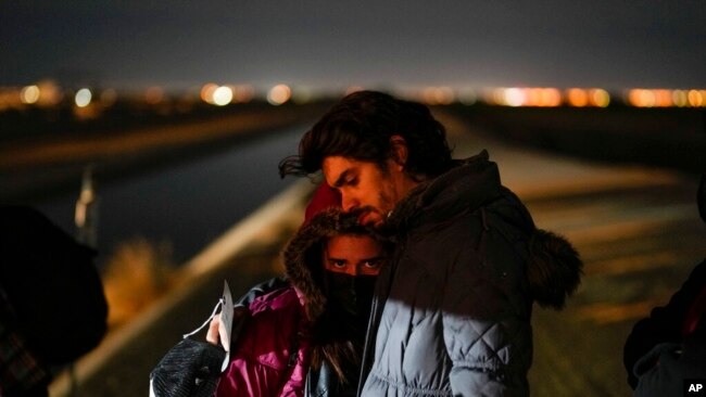 FILE - Cuban migrant Mario Perez holds his wife as they wait to be processed to seek asylum after crossing the border into the United States on Jan. 6, 2023, near Yuma, Ariz.