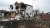 A crater of an explosion is seen next to a destroyed house after a Russian rocket attack in Hlevakha, Kyiv region, Ukraine, Jan. 26, 2023. 