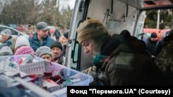 Ольга Беленко раздает медикаменты жителям села Херсонской области.