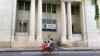 FILE - People onboard a trishaw pass in front of the Yangon stock exchange building in Kyauktada township in Yangon, Myanmar, Nov. 12, 2021. A report released by the World Bank on Jan. 30, 2023, said Myanmar's economy is expected to see growth by the end of September.