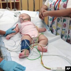 This photo provided by Judy Wei shows her daughter, Rylae-Ann Poulin, the first time she was admitted to an ICU. (Judy Wei via AP)