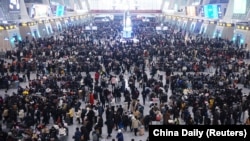 FILE — Travelers pack the Hangzhou East railway station in Hangzhou, Zhejiang province, China, Jan. 20, 2023. China will soon ease visa restrictions for people visiting from the U.S., the country's latest effort to attract foreign travelers since reopening its borders this year. 
