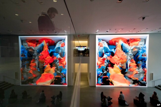 Visitors view artist Refik Anadol's "Unsupervised" exhibit at the Museum of Modern Art, Wednesday, Jan. 11, 2023, in New York. The new AI-generated installation is meant to be a thought-provoking interpretation of the New York City museum's prestigious collection. (AP Photo/John Minchillo)