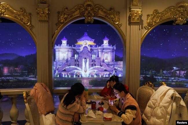 People sit in a restaurant during Spring Festival and Lunar New Year celebrations in Beijing, China, Jan. 23, 2023. Lunar New Year holiday trips inside China surged 74% from last year after authorities scrapped COVID-19 travel curbs, state media reported Jan. 28, 2023.