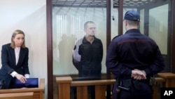 Journalist Andrzej Poczobut, center, stands in a defendants' cage during a court session in Grodno, Belarus, Jan. 16, 2023. 