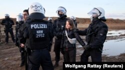 Petugas kepolisian menahan aktivis lingkungan Greta Thunberg yang bergabung dalam aksi protes menentang perluasan tambang di Luetzerath, Jerman, pada 17 Januari 2023. (Foto: Reuters/Wolfgang Rattay)