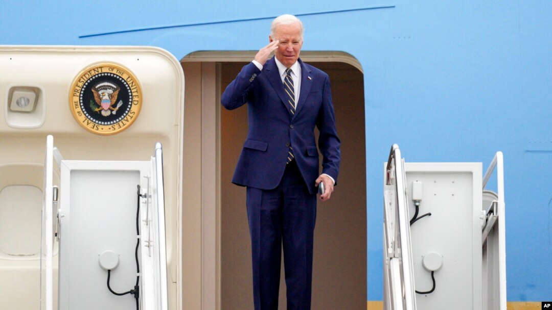 President Joe Biden returns a salute as he boards Air Force One at Andrews Air Force Base, Md., Jan. 19, 2023, en route to California. 