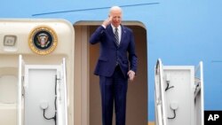 President Joe Biden returns a salute as he boards Air Force One at Andrews Air Force Base, Md., Jan. 19, 2023, en route to California. 
