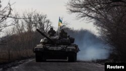 Ukrainian servicemen ride atop a tank near the front-line town of Bakhmut in Donetsk region, Jan. 20, 2023.