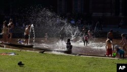 Anak-anak bermain air di Victoria and Albert Museum, London, Inggris, Jumat, 12 Agustus 2022. Inggris menghadapi gelombang panas yang diperkirakan akan mencapai suhu 35 derajat Celcius minggu depan. (AP/Manish Swarup)