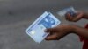 FILE - A person holds a new 1000 naira note as the Central Bank of Nigeria releases the notes to the public through the banks in Abuja, Nigeria, Dec. 15, 2022.