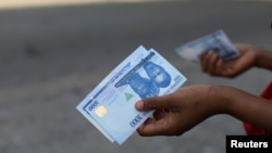 FILE - A person holds a 1000 naira note in Abuja, Nigeria, Dec. 15, 2022.