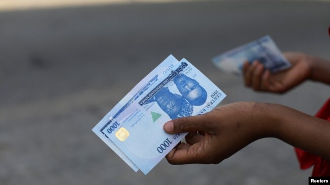 FILE - A person holds a 1000 naira note in Abuja, Nigeria, Dec. 15, 2022.