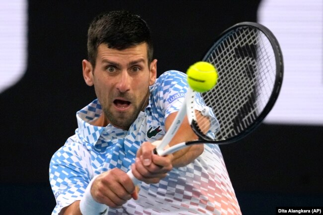 Novak Djokovic of Serbia plays a backhand return to Stefanos Tsitsipas of Greece during the men's singles final at the Australian Open tennis championship in Melbourne, Australia, Sunday, Jan. 29, 2023. (AP Photo/Dita Alangkara)